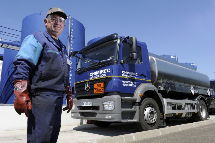 un employé de chimerec se tient devant un camion et des cuves de l'entreprise